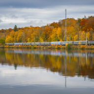 Swedish train running by the lakeside at autumn.